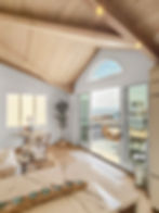 Bright, modern living room with vaulted wood ceiling, marble counter, and glass doors opening to a patio with ocean view; cozy and serene.