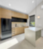 Modern kitchen with wood cabinets and black appliances, expertly designed for home remodeling. A large island and natural light create a bright, inviting space on Barranca Dr. Monterey Park, CA.