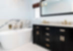Expertly designed, this modern bathroom features a black vanity, double sinks, white tub, marble accents, and geometric tile flooring—Built to Perfection.