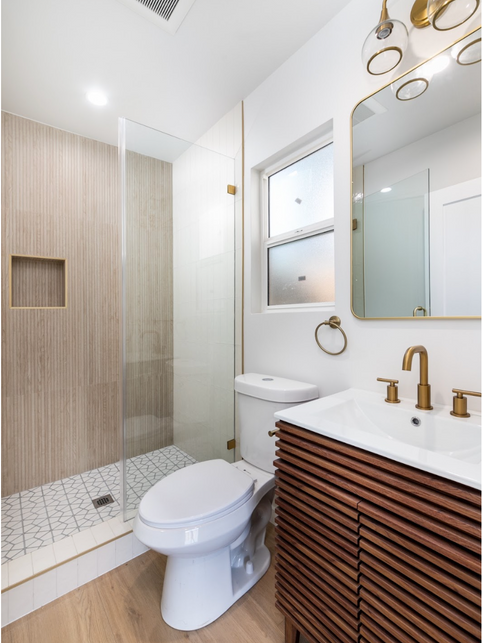 Bathroom with wood floor, slatted wood sink cabinet with gold faucet